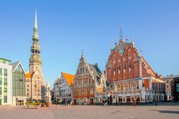 RIGA, LATVIA - September 9, 2008: Tourists admiring Town Hall Square with House of Blackheads and St Peter's church in Riga, Latvia.